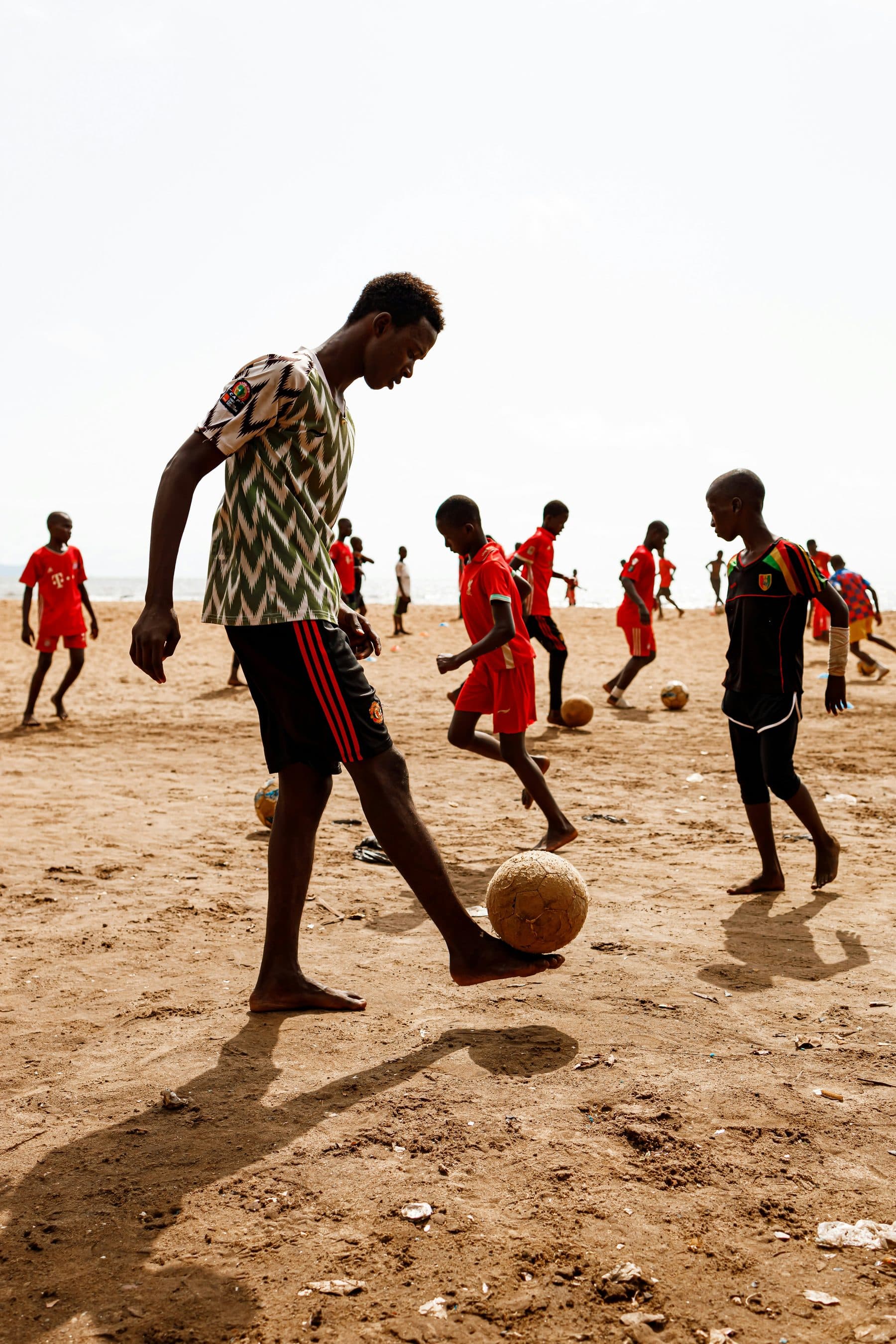 Young footballers playing on a sandy pitch in Africa